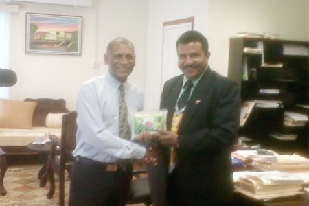 Minister of Agriculture Dr. Leslie Ramsammy (left) presents Trinidad and Tobago’s Minister of Food Production Jairam Seemungal with a package of rice. 