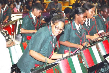 Three members of the Bishop’s High School steel pan orchestra smile as they perform in the Republic Bank Mashramani Pan-o-rama Steel Band Competition.  