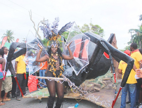 There came a big spider: A Digicel queen costume heading into the National Park yesterday during the Annual Mashramani Costume and Float Parade. Digicel’s band featured birds and insects. (Photo by Arian Browne)