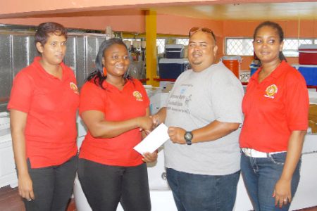 Troy Yhip, the Youth Development Officer (YDO) and tournament coordinator of the GRFU, accepts the sponsorship cheque from one of Hamson’s managers, Emilia Nwankwo to aid with the GRFU/Hamson’s Under-14 Mashramani tournament as other representatives of the company looks on. (Orlando Charles photo)