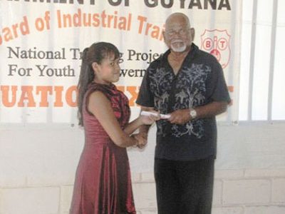 Chairman of the Board of Industrial Training (BIT), Dr. Dale Bisnauth presents a certificate to one of the NTPYE recipients. (GINA photo)
