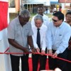 Minister Robeson Benn (left) in his capacity as acting Foreign Affairs Minister cutting the ceremonial ribbon to commission the new CCTV channel. He is assisted by China’s Ambassador to Guyana, Zhang Limin (centre) and Chairman of the board of the National Communications Network, Dr. Prem Misir. (GINA photo)