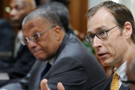 Minister of Finance and Planning Dr Peter Phillips (left) looks on as Jan Kees Martijn, International Monetary Fund mission chief to Jamaica, addresses the media at a press conference held at the office of the Ministry of Finance, Heroes Circle, Kingston, yesterday. (Jamaica Gleaner photo)