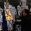 An activist from an anti-North Korea civic group burns a portrait of North’s leader Kim Jong-un during a rally against North Korea’s nuclear test near the U.S. embassy in central Seoul February 12, 2013. The placards read, “Let’s pulverize North Korea’s nuclear war provocations!” (L) and “Kim Jong-un out!” (R)
REUTERS/Kim Hong-Ji