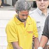 Murder accused Ganesh Thackoor is escorted to the Siparia Magistrates' Court yesterday, charged with the murder of Stella Rampersad. (Trinidad Express photo)