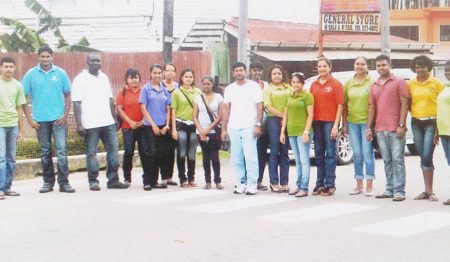 Republic Bank Rose Hall branch staff stand near a repainted pedestrian crossing