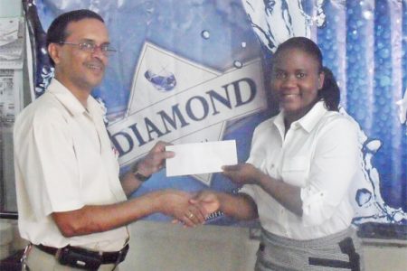 DDL Sales Manager Alexis Langhorne hands over the sponsorship cheque to Shiv Nandalall of the Guyana Chess Federation.
