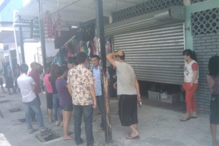 The family of Chinese National congregates in front of the store as police ranks carry out investigations on the scene.
