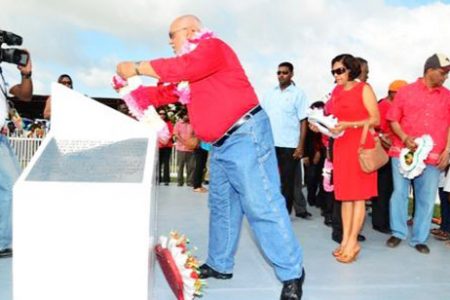 President Donald Ramotar laying a wreath yesterday at Babu John in honour of the party’s late founder and former President, Dr Cheddi Jagan. (GINA photo)