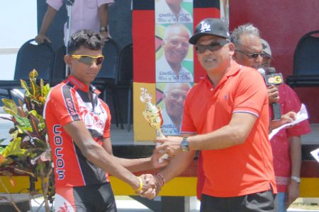 Back to Back! Star cyclist Raynauth Jeffrey receives his  trophy for winning the 16th annual Cheddi Jagan Memorial 55-mile road race from CEO of BK International, Brian Tiwari. (Orlando Charles photo)
