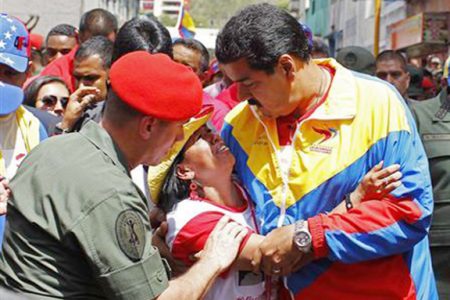 Venezuela’s Vice President Nicolas Maduro consoles a supporter of deceased Venezuelan leader Hugo Chavez, as his coffin is driven through the streets of Caracas, yesterday. REUTERS/Carlos Garcia Rawlins
