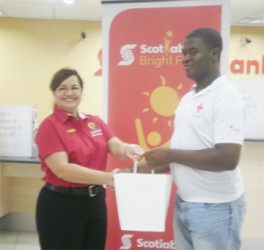 Scotiabank Country Manager Amanda St Aubyn (left) presents Collis Augustine with his iPad