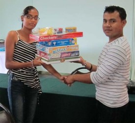 Padmanie Chattergoon (left) representative of Diamond’s student club receives a set of games from DAG Committee Member James Williams.  