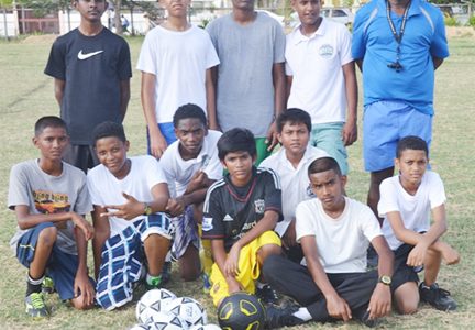 Coach Mark Charles surrounded by his young Alpha United players.
