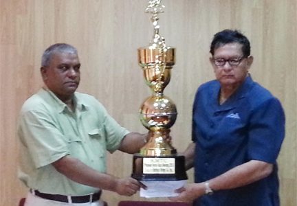 Omdatt Samaroo, Chief Executive Officer of Berbice Bridge Incorporated, (left) hands over the sponsorship trophy and cheque to President of the Kennard Memorial Turf Club Cecil Kennard on Monday.