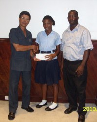  CARIFTA athlete, Tirana Mitchell receives a cheque from Ming’s Products and Services Limited Director Colin Ming in the presence of Mark Scott, coach of the CARIFTA Team at the Ming’s Products and Services Limited Kingston. 