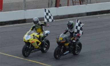 Super! Super Bike Champions at yesterday’s meet Stephen Vieira (professional) and Nickel Seeraram (amateur) waves their chequered flags. 