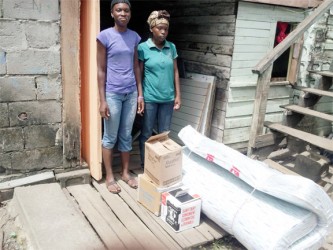 Luwana Marshall (left) with a representative of the Masjid Najim and Social Centre in Albouystown stand with some of the donated goods. 