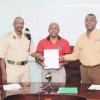 Donald Sinclair, Director of Flex Night Inc (centre) with Director of Prisons, Dale Erskine (left) and CEO of Demerara Mutual Life Assurance Society Ltd, Keith Cholmondeley holding the MOU.