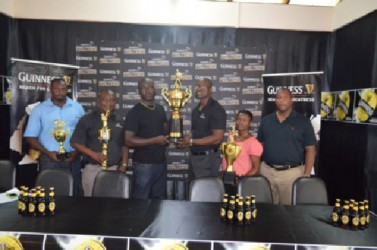 Guinness Brand Manager Lee Baptiste (Centre right) presents one of the tournament prizes to one of the organizers while other officials look on.    