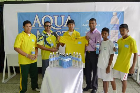 Captain of the Guyana Badminton Team Narayan Ramdhani (third from left) receives one of the team shirts from Banks DIH Brand Manager Errol Nelson while Guyana Badminton Association President Gokarn Ramdhani (second from left)  and three team members look on.
