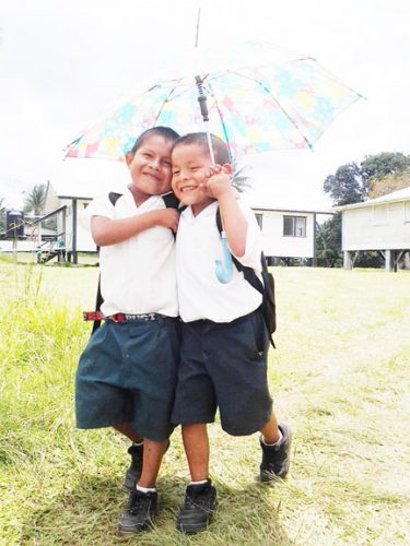 Best buddies: These two
students of the Kako
Primary School share
an umbrella as they
walk back to school