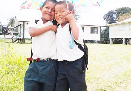 Best buddies: These two
students of the Kako
Primary School share
an umbrella as they
walk back to school