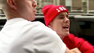 A member of Justin Bieber's staff restrains him