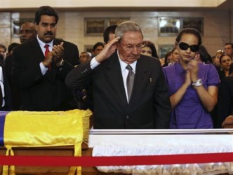 Cuba's President Raul Castro salutes the body of late Venezuelan President Hugo Chavez, which is lying in state, as he visits the wake with Chavez's daughter, Rosa Virginia (R), and Venezuela's Vice-President Nicolas Maduro (2nd L) at the military academy in Caracas March 7, 2013, in this picture provided by the Miraflores Palace.  REUTERS/Miraflores Palace/Handout 