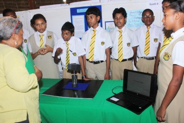 A student of the Queen’s College giving a judge a demonstration of their project ‘The Electric Tower’