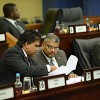 Attorney General Anand Ramlogan, right, and Housing Minister Dr Roodal Moonilal browse through a document during yesterday's sitting of the Lower House in Port of Spain.