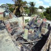 Shawn Hercules attempts to prevent the fire from rekindling at his Clifton Circular Road, Laventille home yesterday after it was set ablaze by arsonists on Monday evening