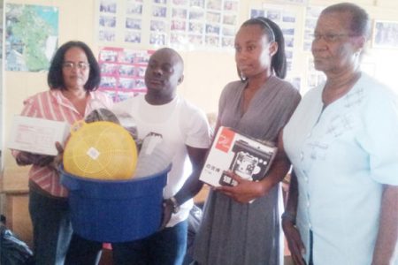 Lisa Ashby (second from right) surrounded by staff of the Guyana Relief Council with some of the donated items. 