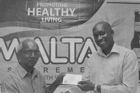 Brand Manager at Banks DIH Clayton McKenzie (right) presents a sponsorship cheque to Secretary of the Guyana Chess Federation Vishnu Rampersaud (left) at Thirst Park. 