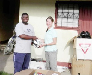 A representative (left) of the Linden group receiving the donation. (US embassy photo)