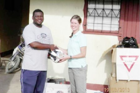 A representative (left) of the Linden group receiving the donation. (US embassy photo)