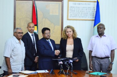 Minister of Finance Dr. Ashni Singh and Resident Representative of the Inter-American Development Bank (IDB) Sophia Makonnen shake hands following the signing of the non-reimbursable financing agreement to the tune of US$5M for small businesses. (Government Information Agency photo) 