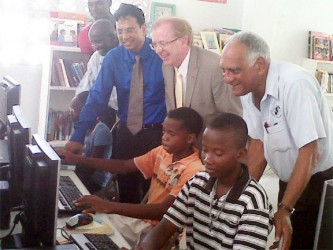 From left to right, Robin Phillips, GT&T CEO Radha Krishna Sharma, Canadian High Commissioner David Devine and Lenny Shuffler look on as youths from the Buxton Youth Development Centre use the computers that were donated. 