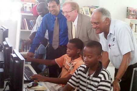 From left to right, Robin Phillips, GT&T CEO Radha Krishna Sharma, Canadian High Commissioner David Devine and Lenny Shuffler look on as youths from the Buxton Youth Development Centre use the computers that were donated.
