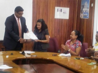 Minister of Tourism Irfaan Ali (left) and President of the Taxi Association Hemwanti Khan shake hands after signing the ethics code launched for taxi drivers yesterday 