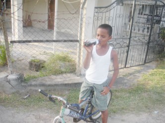 Young lad sipping on a cold drink 