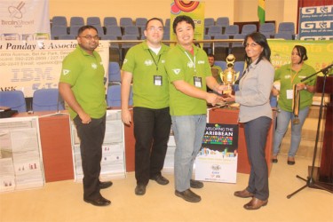 Programmers from the winning team, Sirca, receiving their trophy from Dr Sita Shah-Roth. From left are team members Amanauth Persaud, Jason Plummer and Richard Cheng-Yuen 