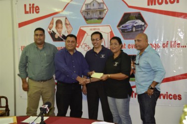 Hand-in-Hand, Human Resources and Administrative Manager, Zaida Joaquin (second right) hands over the cheque to president of the DCB, Raj Singh in the presence of other DCB officials and Director and Fire Manager of the insurance company, Howard Cox.   