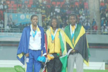 Jevina Straker (center) stands on the podium with her gold medal following her win in the girls’ U20 1500m final in The Bahamas at the Thomas Robinson Stadium.