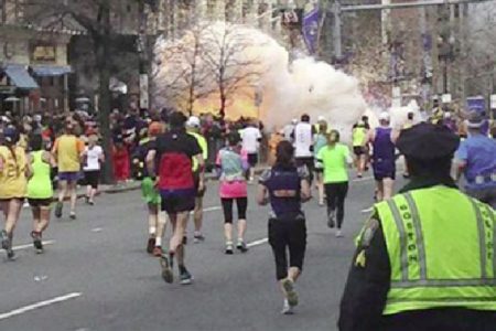 Runners continue to run towards the finish line of the Boston Marathon as an explosion erupts near the finish line of the race in Boston, Massachusetts, April 15, 2013. (Reuters/Dan Lampariello) 