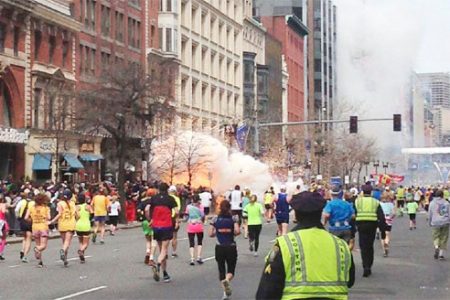Runners continue to run towards the finish line of the Boston Marathon as an explosion erupts near the finish line of the race in this photo exclusively licensed to Reuters by photographer Dan Lampariello after he took the photo in Boston, Massachusetts. REUTERS/Dan Lampariello.