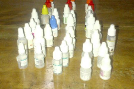 The woman displays the bottles of eye drops she had to use over the past six months.