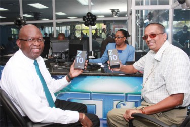 Alex Graham of Tagman Inc (left) and Chief Executive Officer of Sterling Products Limited Ramsay Ali were the first two persons to purchase BlackBerry Z10 smart phones at GT&T’s Blackberry Office yesterday. 