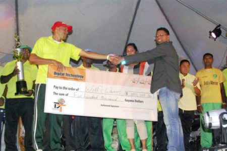 Terrence Sukhu (right, front) hands cheque over to Wolf’s Warriors skipper while team members, supporters and sponsors’ representatives look on