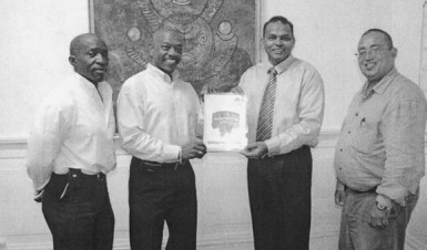 Minister of Sport Dr. Frank Anthony receiving a copy of the GAPF’s five-year Strategic Plan from Vice President of the federation, Edwin Spencer. 